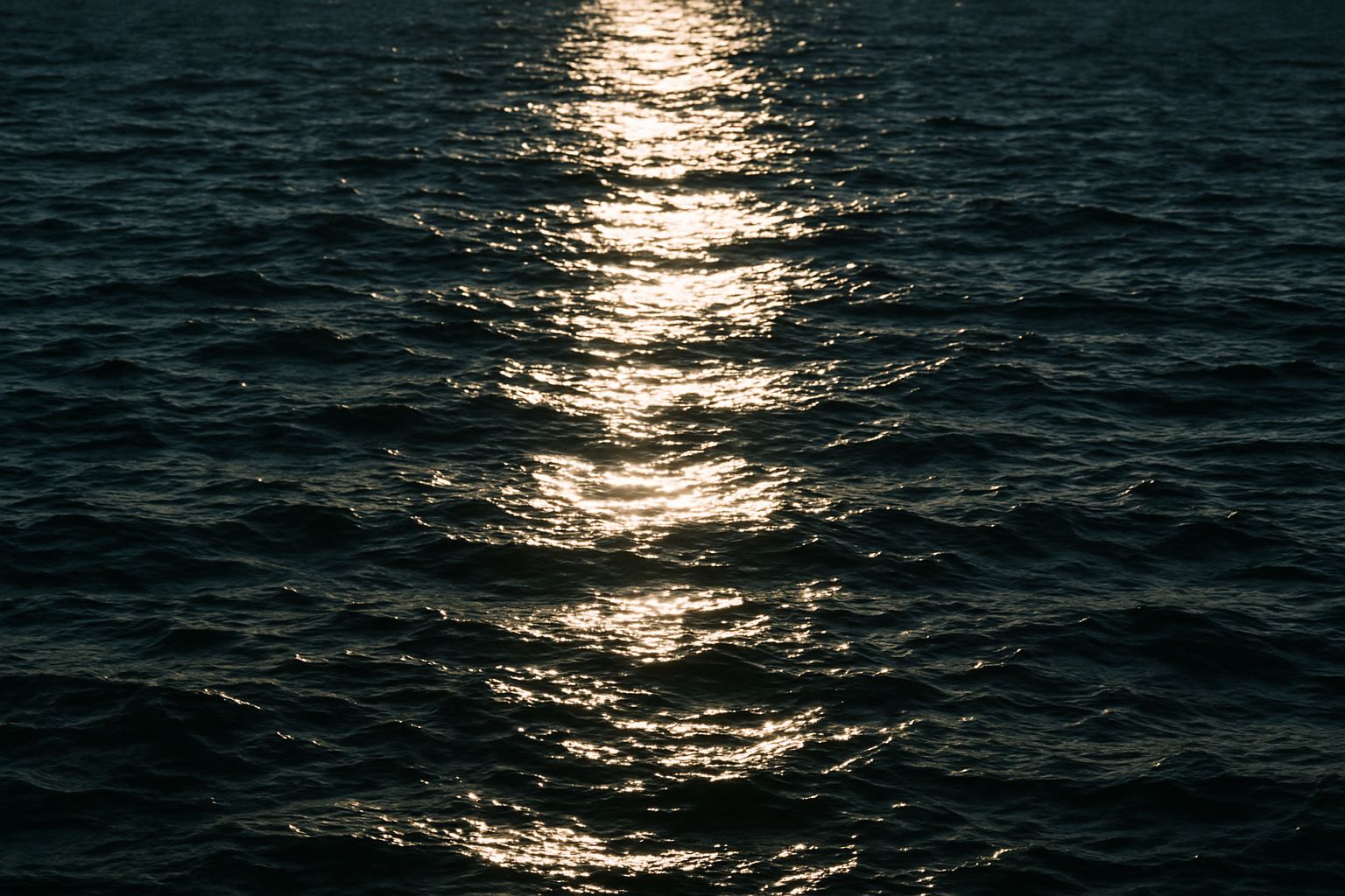 A glare path breaking up across moving water. Every facet of that surface is pointing somewhere different.